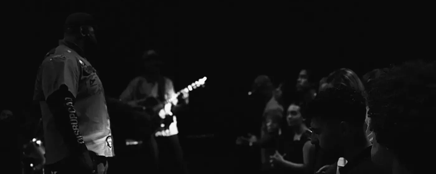 O louvor tocando no palco, com a igreja de pé.