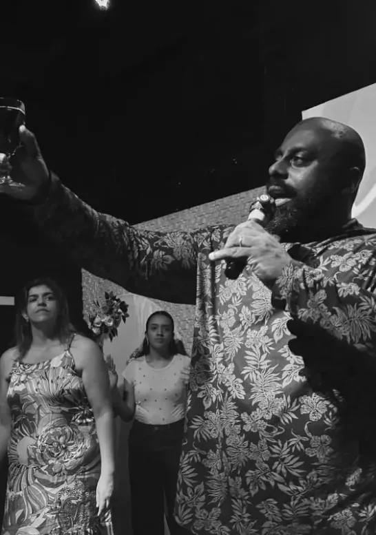 Pastor falando ao microfone na Santa Ceia.