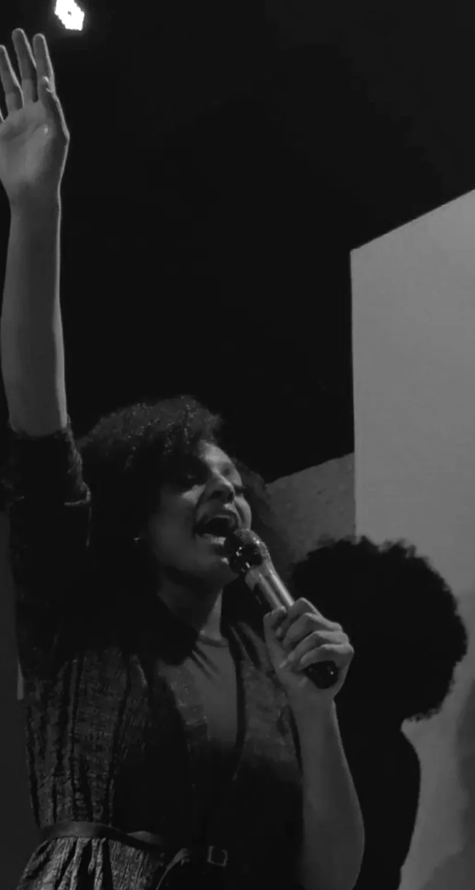 Uma cantora de braço levantado conduzindo o louvor.