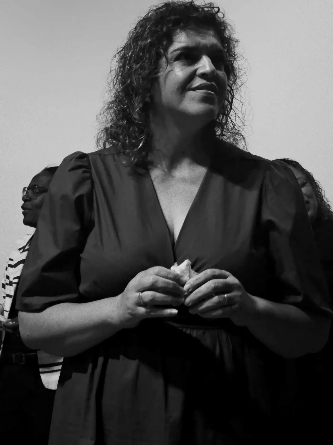 Uma mulher da igreja sorrindo, com o pão da Ceia nas mãos.